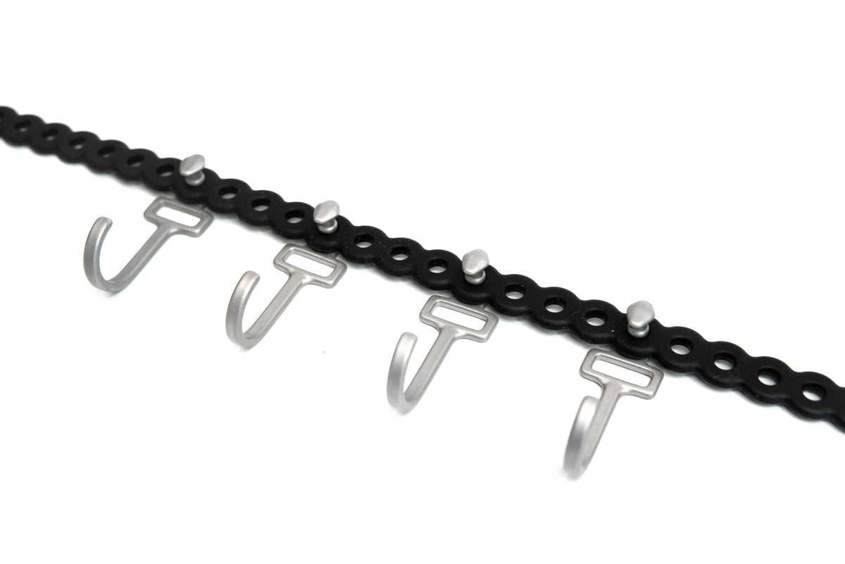 Close-up of HookStuds™ | MODL, a black modular strap with multiple silver hooks and studs, on a white background.