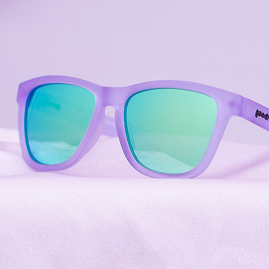 Lilac It Like That!!! goodr sunglasses with a matte purple frame and mirrored green lenses on a purple background.