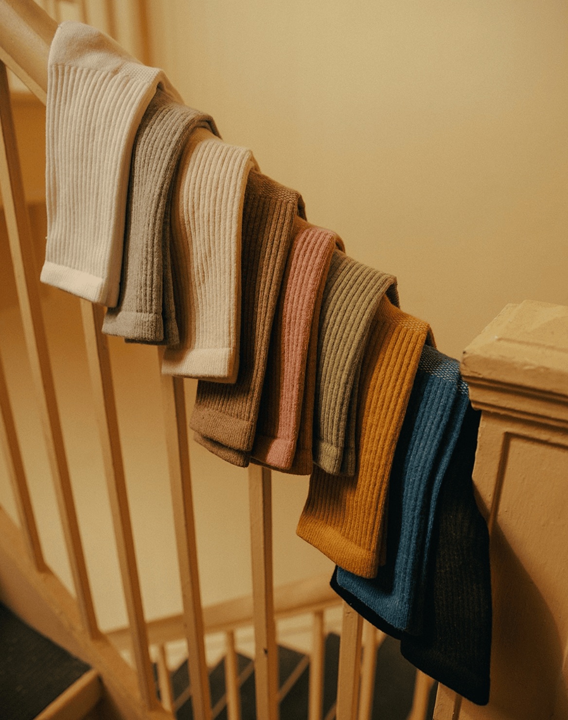 Ribbed Women's Statement Ankle in Cashmere socks by American Trench in multiple colors on a wooden stair railing.