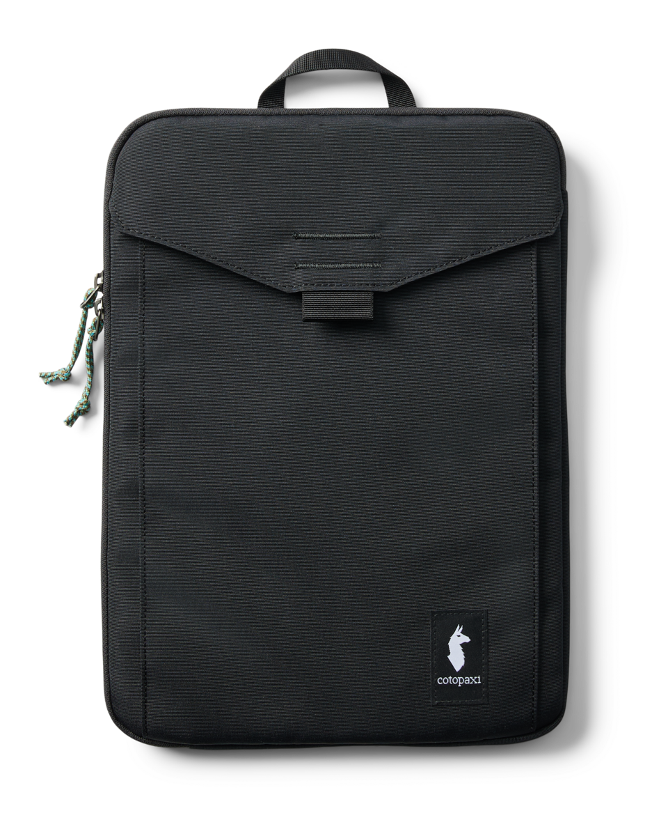 Black Cotopaxi Cada Dia 16-inch laptop sleeve with front pocket and green cord zipper pull on white background.