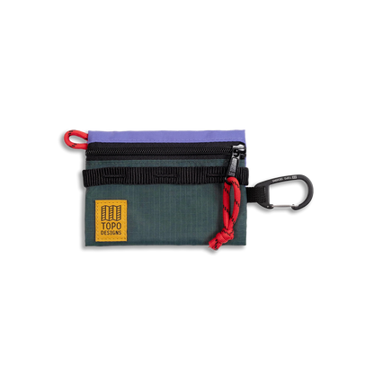 Topo Designs Mountain Accessory Bag in green with a purple top, black zipper, red cord pull, and carabiner clip.