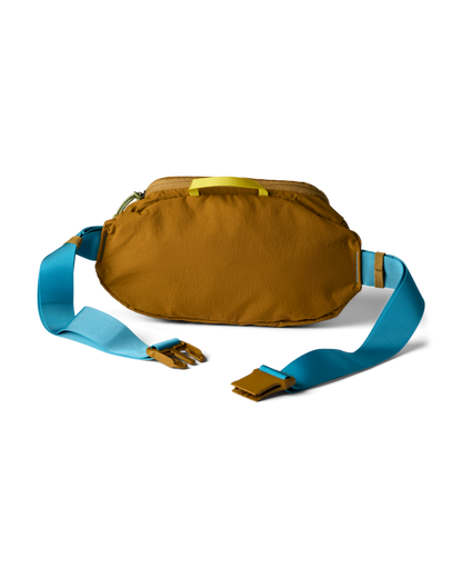 Cotopaxi Empacable 3L Sling in brown with blue strap and yellow handle, unbuckled. Versatile hip pack.