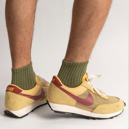 The Solids Quarter Crew | American Trench olive green socks on feet with yellow and red Nike sneakers.