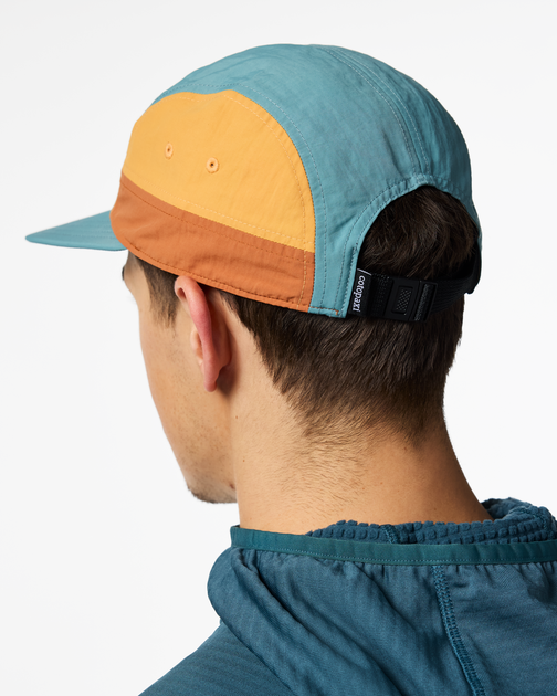 Zen Garden Tech 5-Panel Hat from Cotopaxi, showing the back with teal, peach, and brown panels and an adjustable strap.