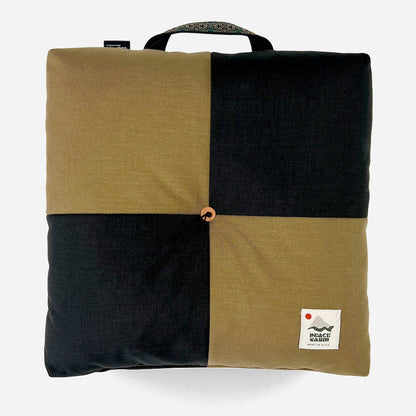 Wanderer 'QUAD' Outdoor Cushion by Media Mercantile, black and olive green checkerboard design with handle.