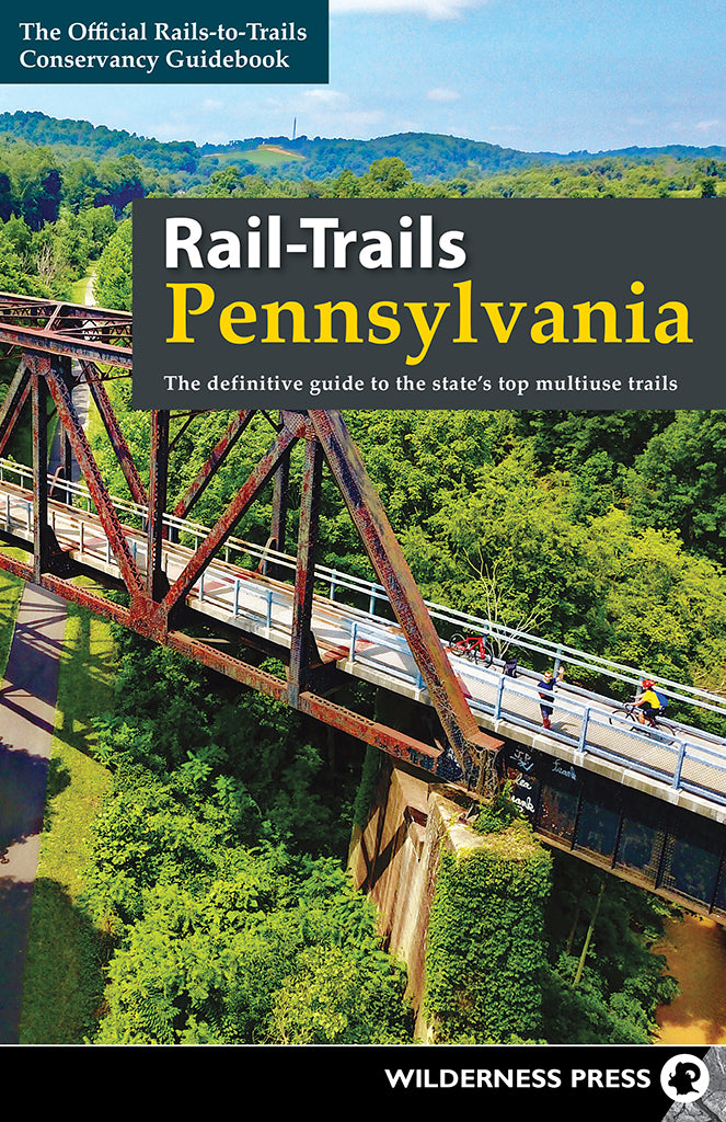Cover of Rail-Trails Pennsylvania | Media Mercantile guidebook, showing cyclists on a scenic trail bridge over a lush forest.