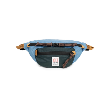 Topo Designs Mountain Waist Pack in light blue and dark green with brown accents, displayed on a white background.