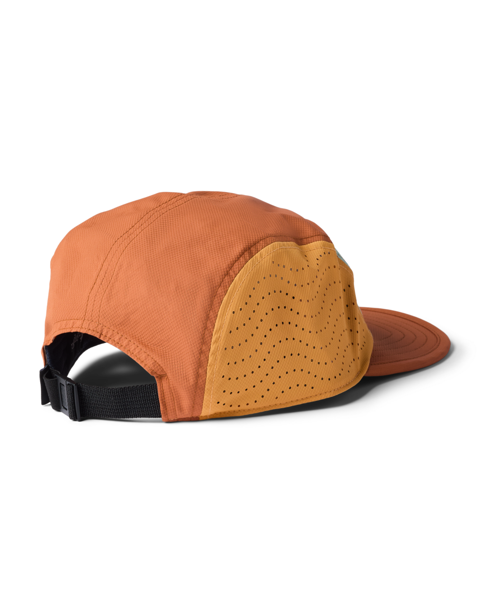 Cotopaxi Tech Plus 5-Panel Hat, side view showing orange fabric, perforated yellow panel, and black adjustable strap.