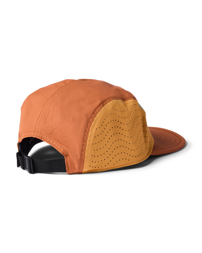 Cotopaxi Tech Plus 5-Panel Hat, side view showing orange fabric, perforated yellow panel, and black adjustable strap.