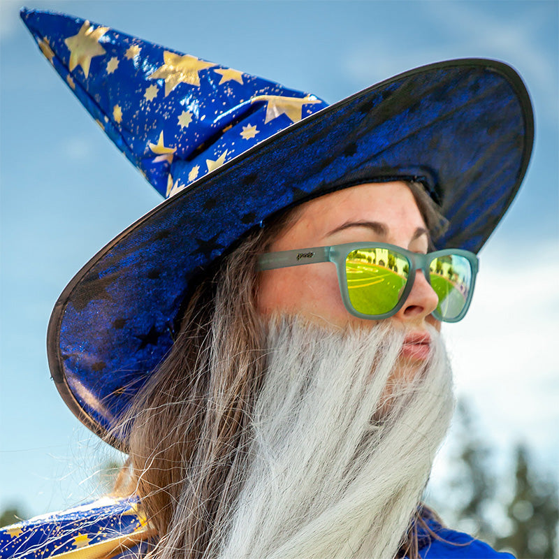 Sunbathing with Wizards goodr sunglasses on a person in a wizard hat & white beard, reflecting a sunny road.
