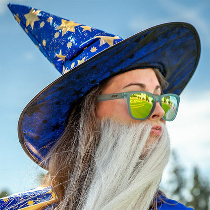 Sunbathing with Wizards goodr sunglasses on a person in a wizard hat & white beard, reflecting a sunny road.