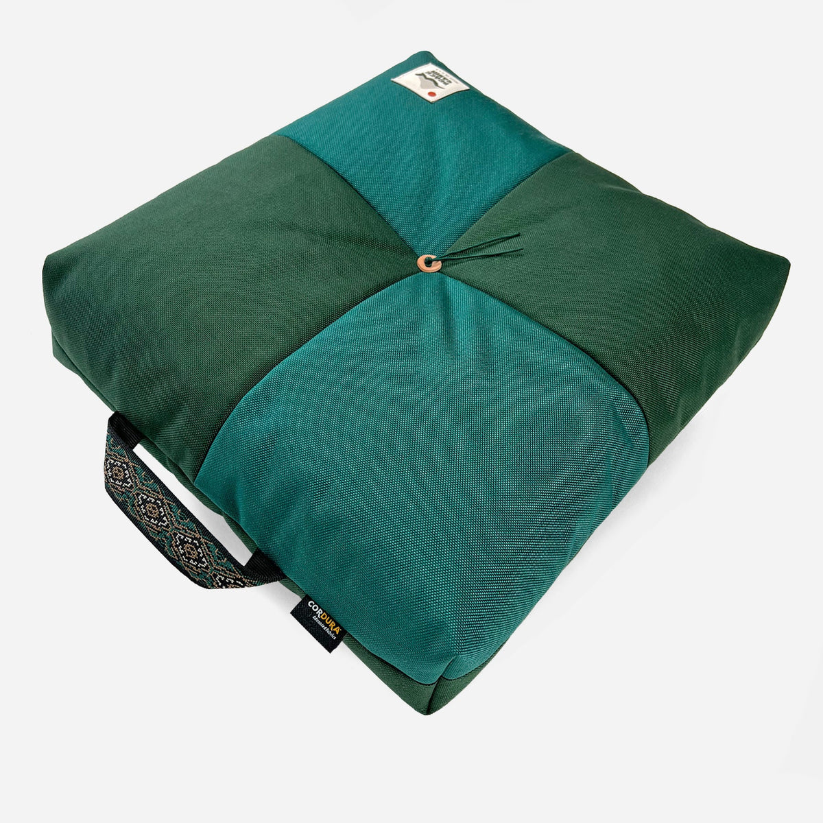 Wanderer 'QUAD' Outdoor Cushion. Dark & teal green fabric, square design with central button, patterned handle & Cordura.