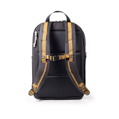 Topo Designs Commuter Backpack, black with tan straps, showing the back with sternum strap and padded back panel