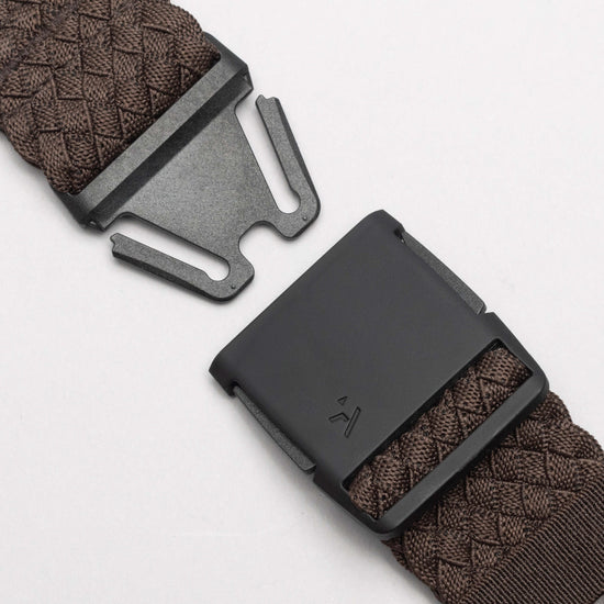 Close-up of the unfastened black buckle and brown woven strap of the Arcade Belts Futureweave Stretch Belt