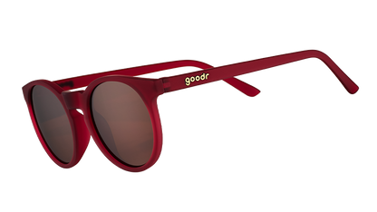 I'm Wearing Burgundy? goodr sunglasses featuring round, matte red frames and brown polarized lenses, angled.