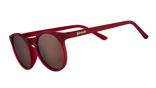 I'm Wearing Burgundy? goodr sunglasses featuring round, matte red frames and brown polarized lenses, angled.