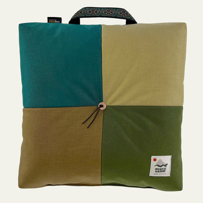 Wanderer 'QUAD' Outdoor Cushion by Media Mercantile, four panels in teal, tan, olive, brown, with handle and button.