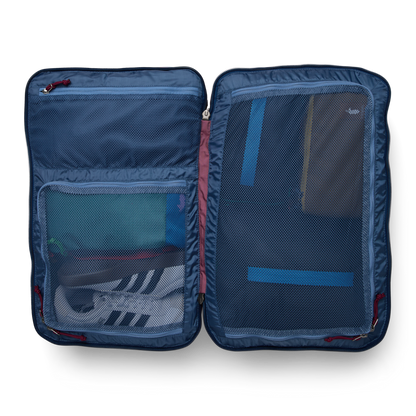 Cotopaxi Allpa 35L Travel Pack open, showing organized interior with mesh pockets holding shoes and essentials