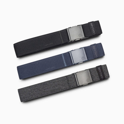 Arcade Belts Atlas Stretch Belt in black, blue, and gray with metallic buckles, arranged diagonally.