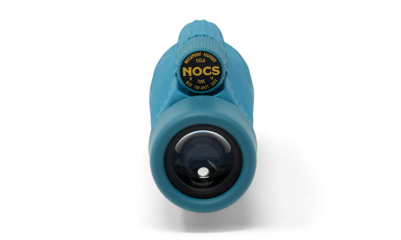 Close-up front view of a blue Nocs Provisions Field Tube 32mm Monocular showing the lens and focusing ring with branding.