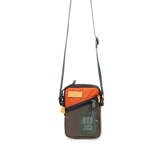 Topo Designs Mini Shoulder Bag in olive green and orange, with black zippers and a green shoulder strap.