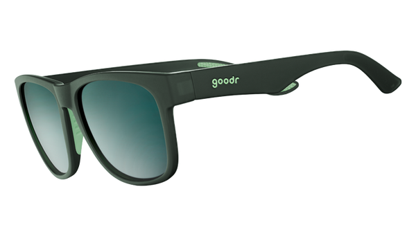 Mint Julep Electroshocks goodr sunglasses in dark green with blue gradient lenses, angled on a white background.