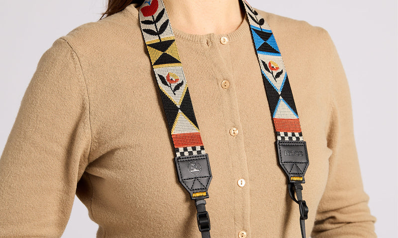 NocLoc Woven Tapestry Neck Strap by Nocs Provisions, featuring colorful floral & geometric patterns, worn over a tan cardigan.